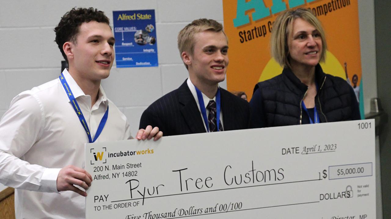 students standing with a winner check