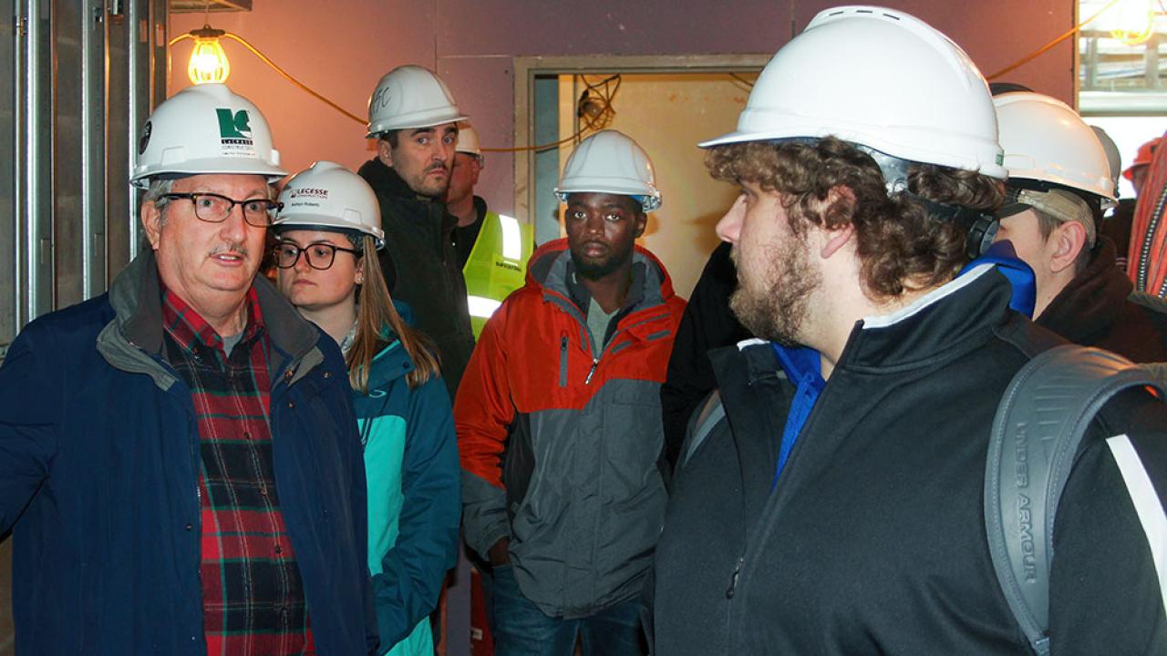 Professor with students in construction site