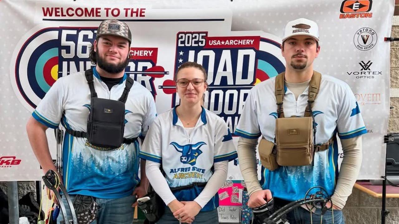Alfred State archers pose in front of a sign