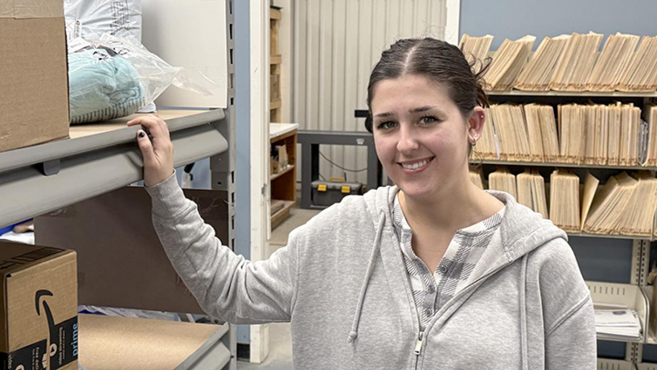 Smiling Rain Middendorf in the mail room at Alfred State