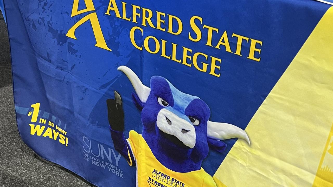 Alfred State table banner with Big Blue on it