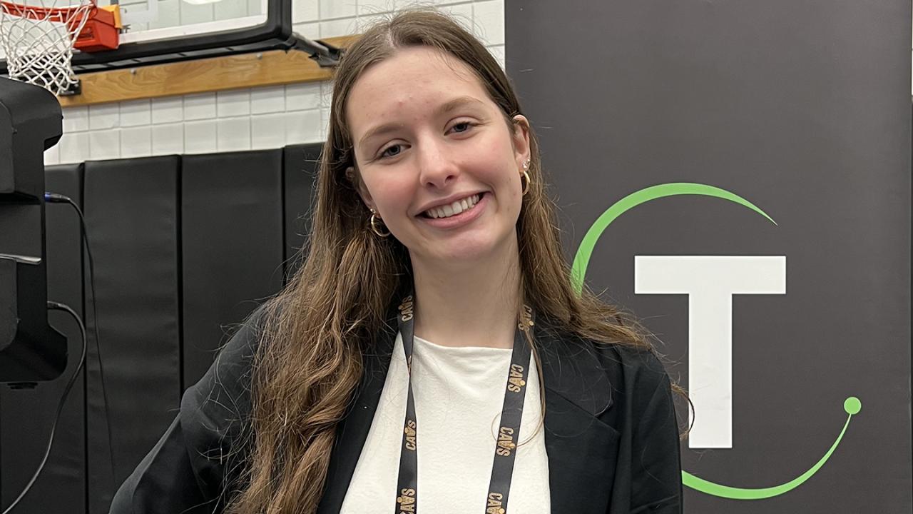 Grace Hildreth stands in front of a sign